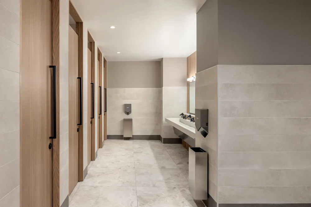 City Hall gender-neutral washroom — Stall corridor with floor-to-ceiling doors