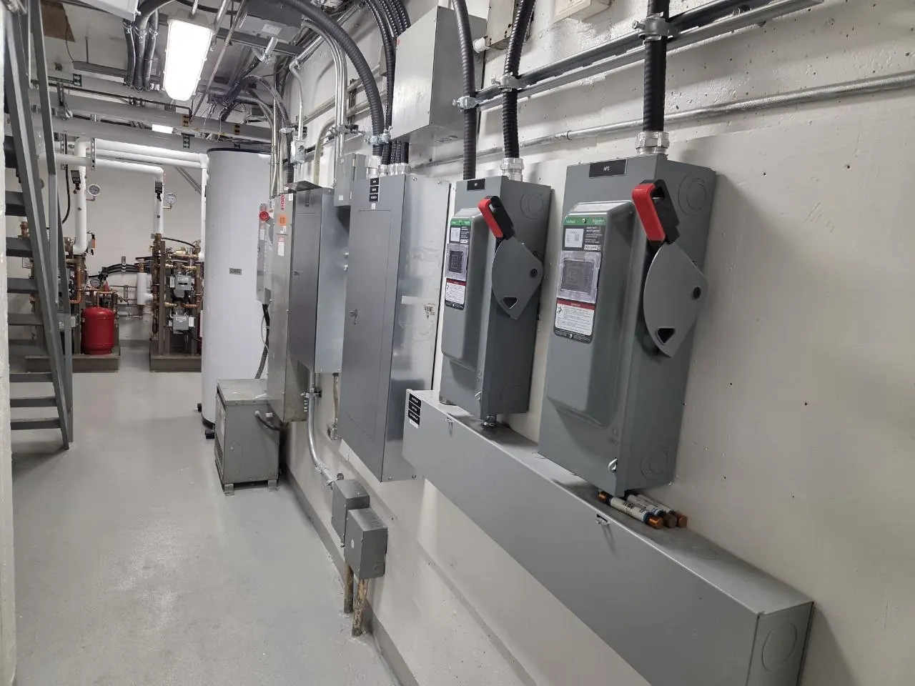 Arrow electrical site photo — Disconnect switches and distribution in an equipment room