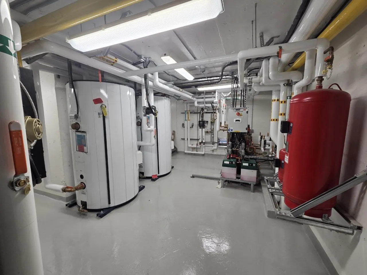 Arrow mechanical site photo — Mechanical room — storage tanks, expansion tank, and hydronic piping
